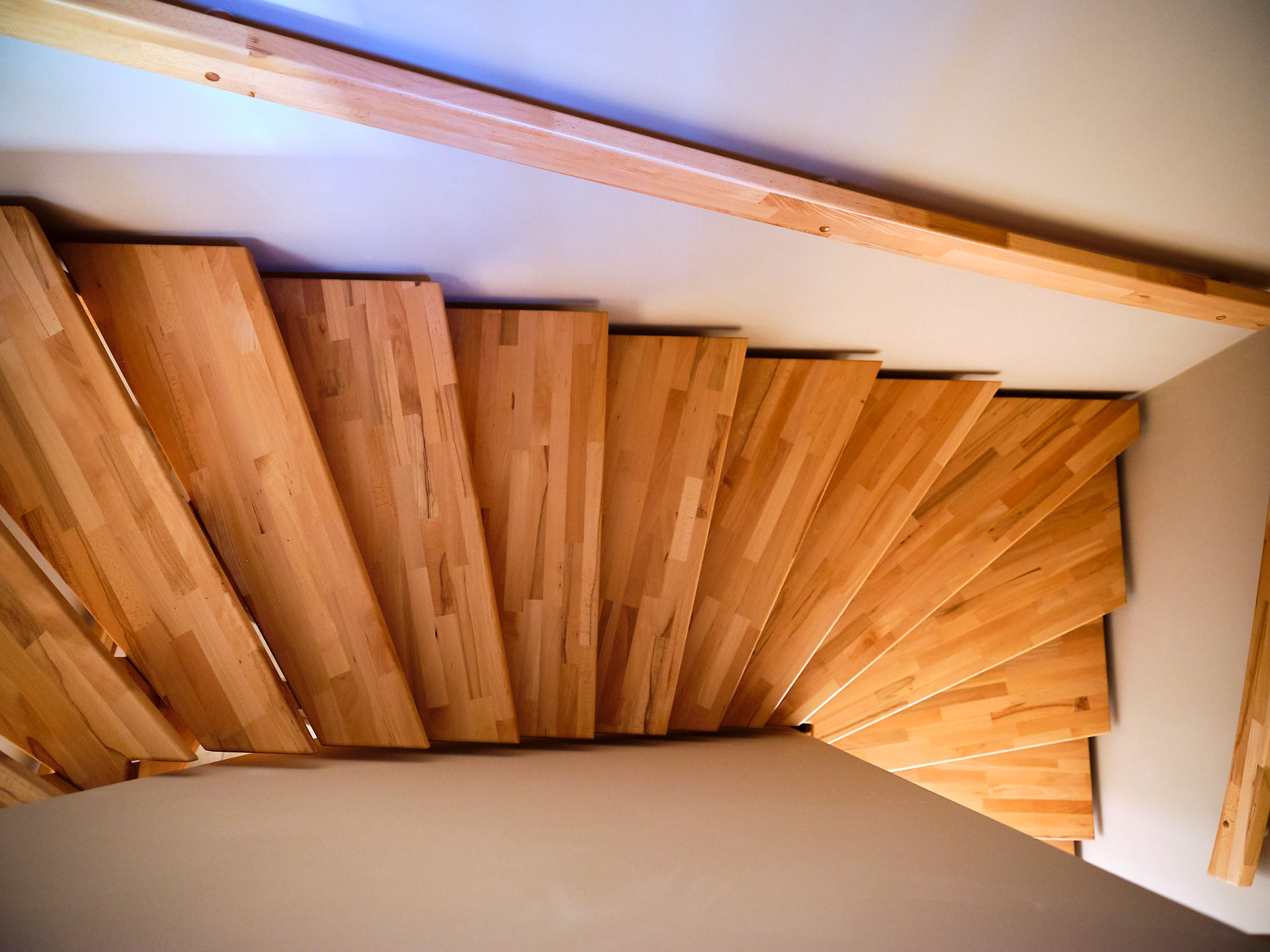 Massivholztreppe über drei Ebenen, die Funktionalität und natürliches Wohndesign in der Doppelhaushälfte verbindet.